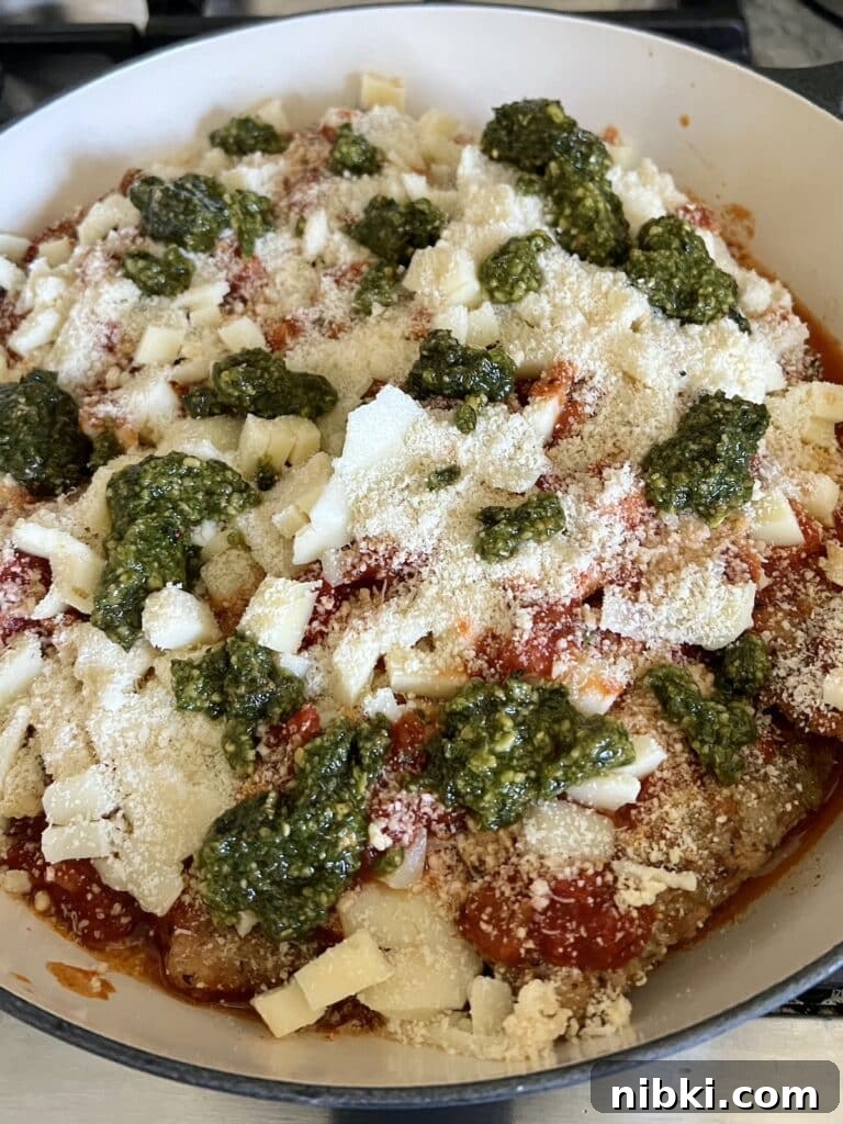 Skillet Chicken Parmesan with Pesto 9 Grated cheese and pesto layered on top of mozzarella.
