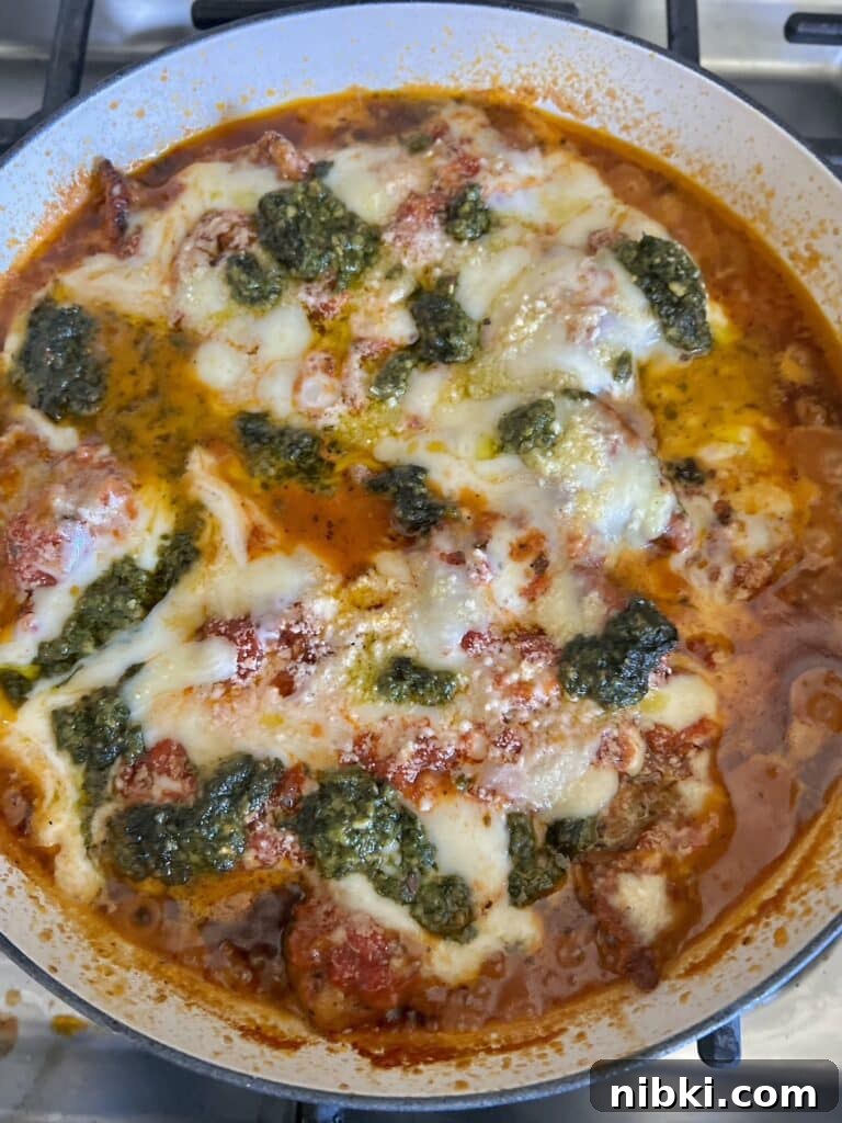 Skillet Chicken Parmesan with Pesto 10 Finished chicken parm with pesto in pan.