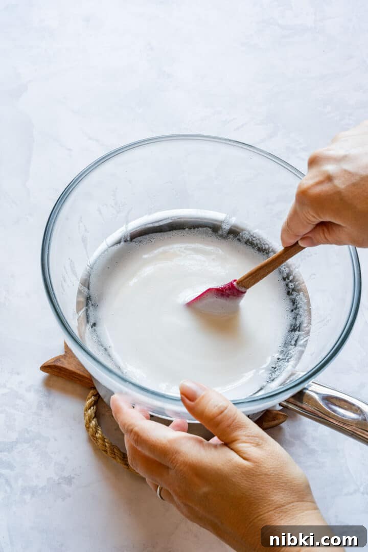 Stirring warmed egg whites and sugar until smooth for Swiss meringue.