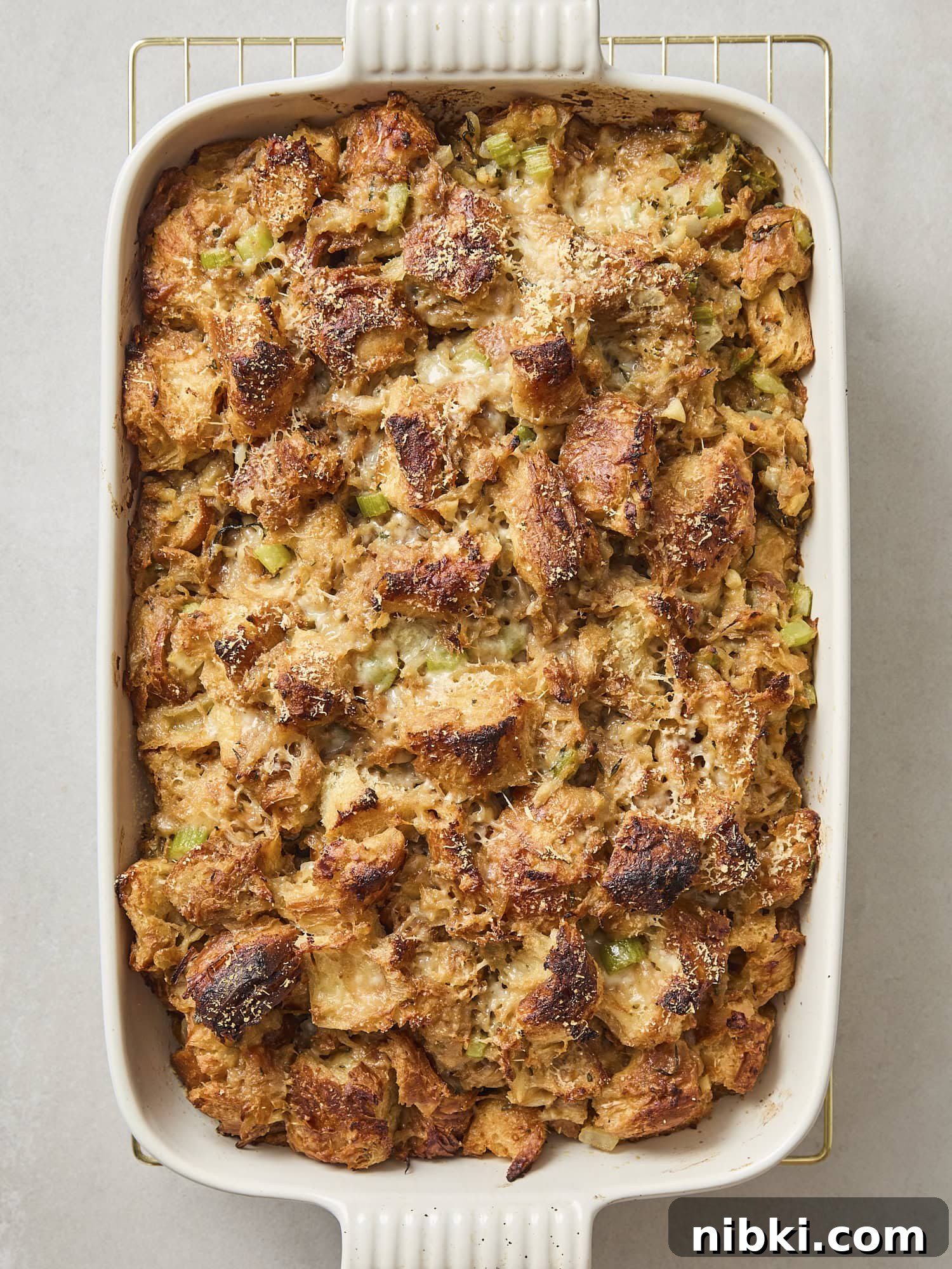 Caramelized Onion and Croissant Stuffing Recipe 13 Baked stuffing in a white baking dish with crispy browned topping.