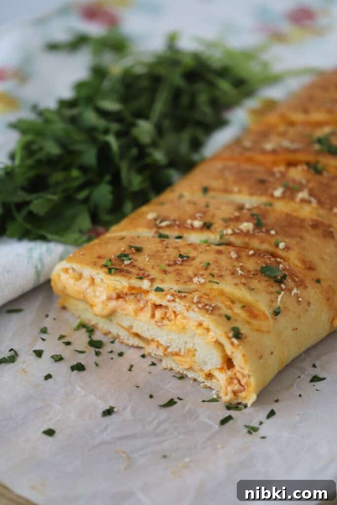 A baking sheet with buffalo chicken stromboli missing a slice.