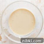 Crispy Fried Banana Fritters Recipe with Cinnamon Sugar 4 Thick batter in a glass bowl.