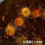 Crispy Fried Banana Fritters Recipe with Cinnamon Sugar 7 Frying the bananas in hot oil.
