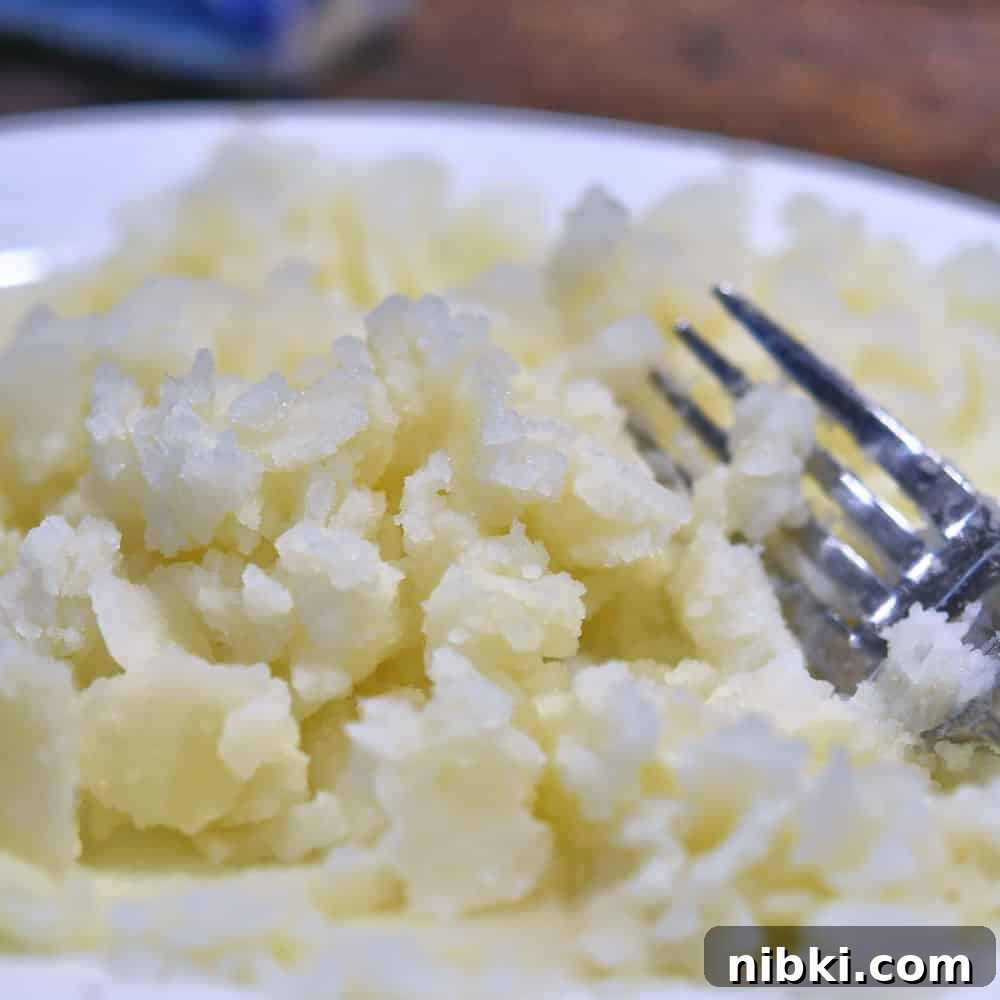 Potato Dinner Rolls: Bread Machine, Hand, or Mixer 5 mashing the potato with a fork on a white plate