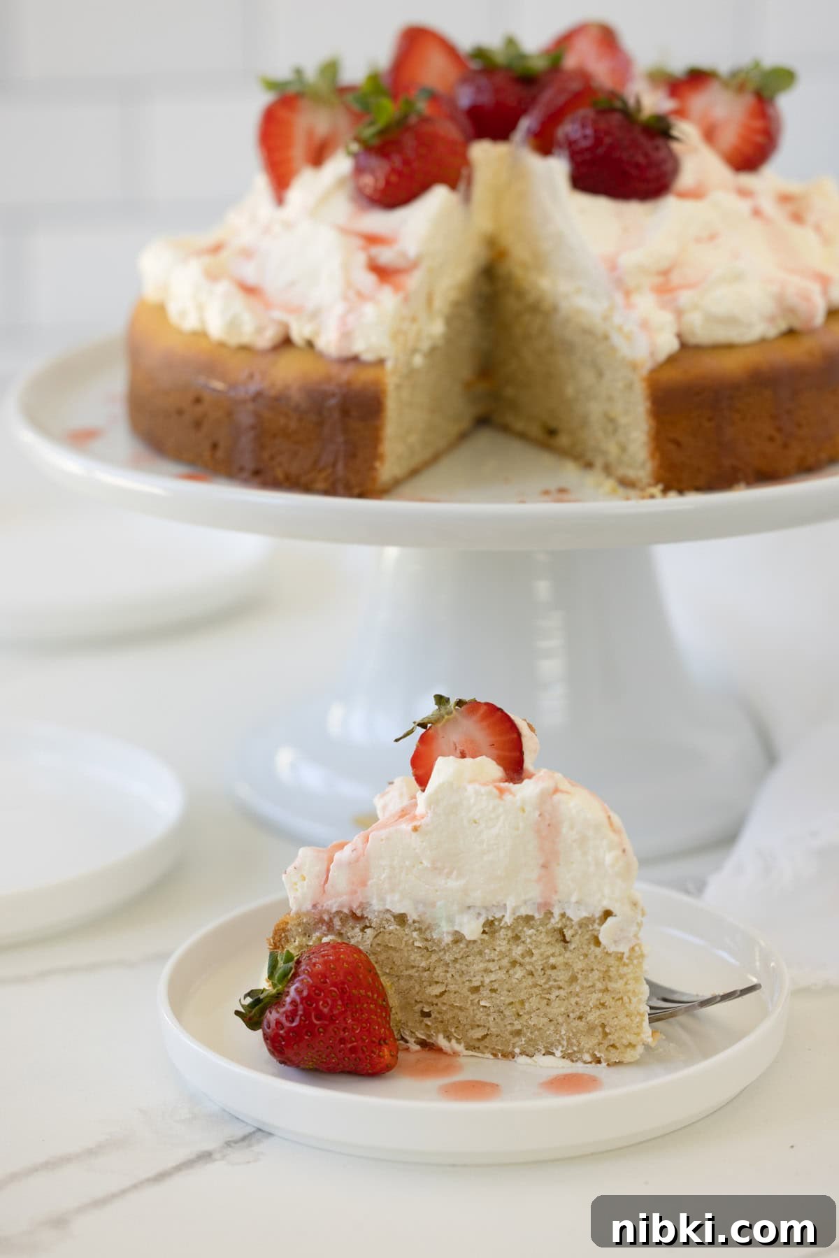Gluten-Free Strawberry Shortcake Cake Recipe 11 A slice of strawberry shortcake cake with whipped cream and strawberries.