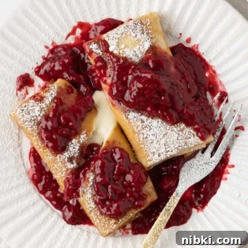 Gluten-Free Strawberry Shortcake Cake Recipe 12 A plate of cheese blintzes with thick raspberry sauce and a fork.
