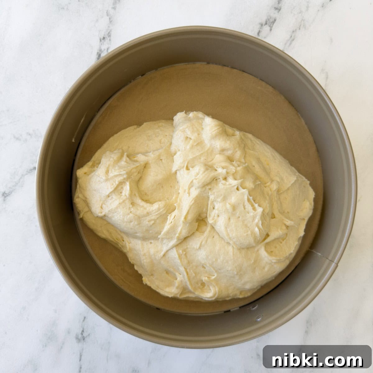 Gluten-Free Strawberry Shortcake Cake Recipe 9 Mixed cake batter in a springform pan lined with parchment paper.