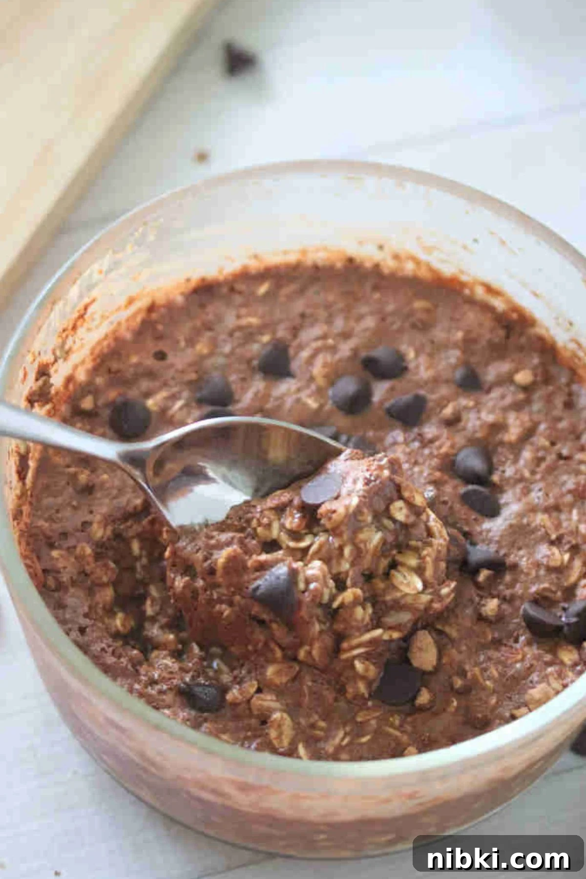 Dairy-Free High-Protein Chocolate Overnight Oats 2 Large bowl with chocolate protein overnight oats topped with chocolate chips and a spoon in the bowl.