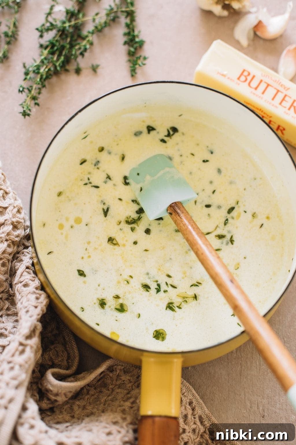 melted butter, cream, garlic and thyme in small saucepot with spatula for mashed potatoes