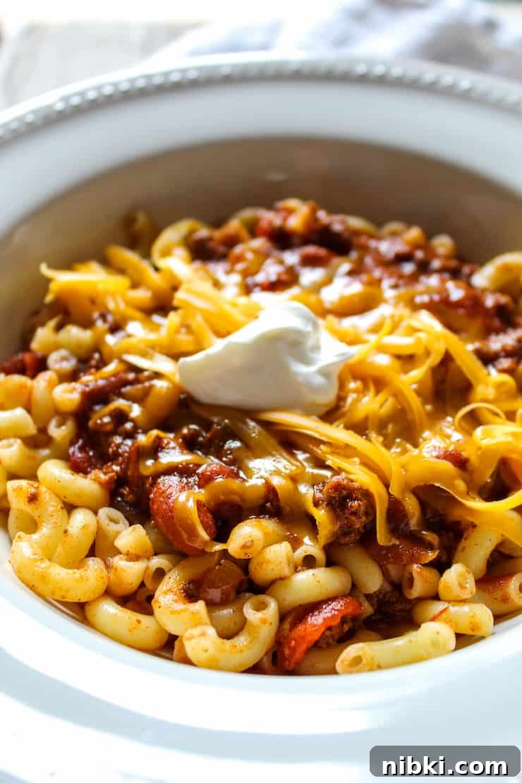 Homestyle Cheesy Chili Mac with Ground Beef and Pasta 4 Close up of chili in serving bowl with toppings.