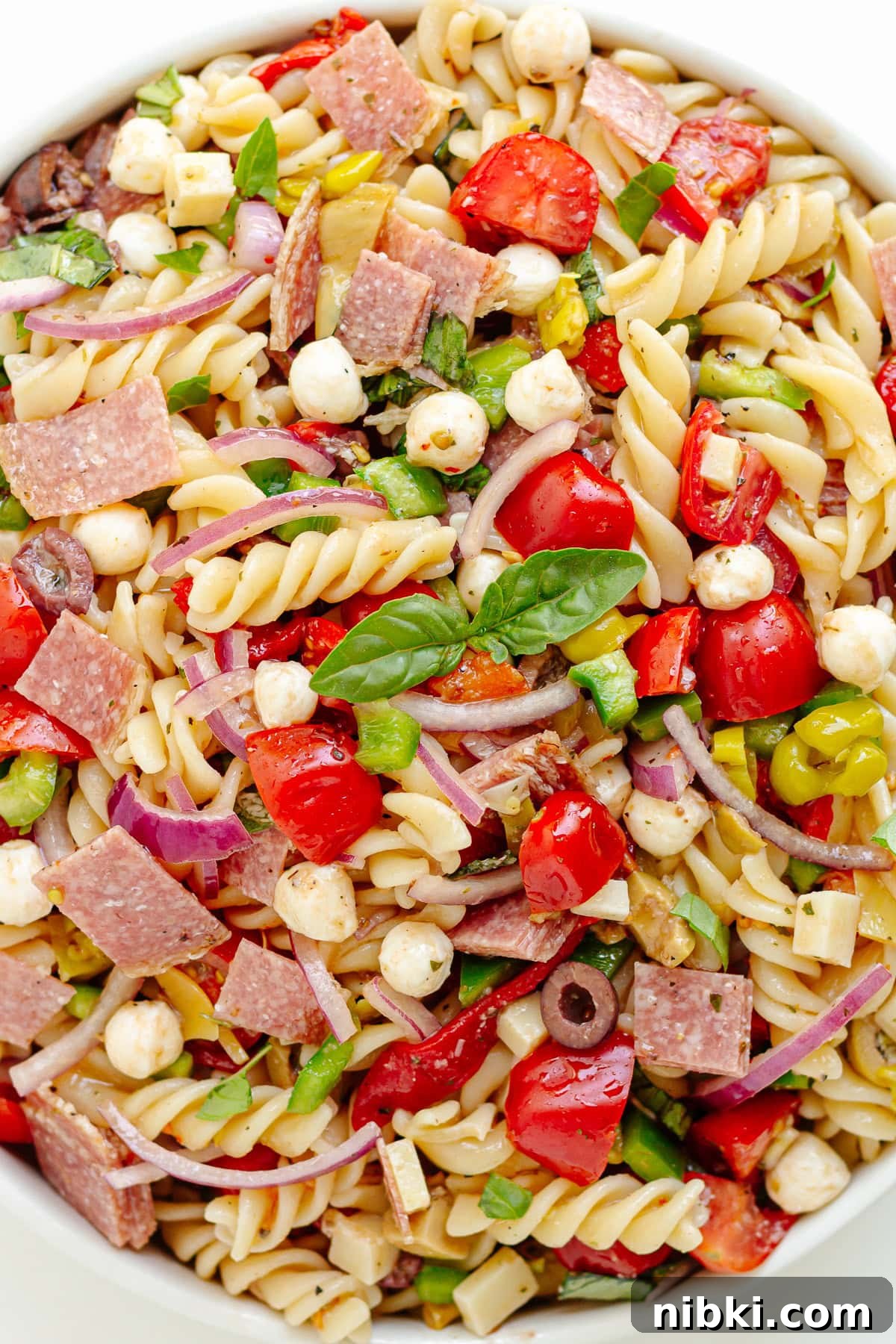 Antipasto Pasta Salad Recipe with Zesty Italian Dressing 2 Antipasto pasta salad in a white serving bowl.
