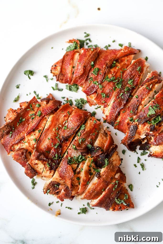 Air Fryer Bacon-Wrapped Chicken Breast: Crispy and Juicy 2 air fryer bacon wrapped chicken breast with crispy bacon on white plate