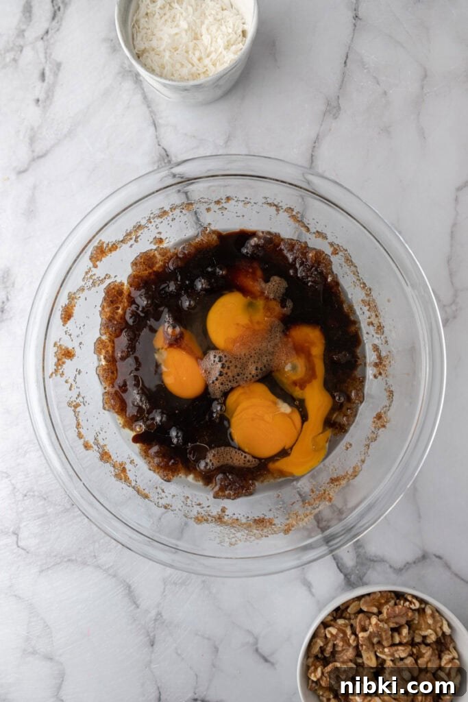 Moist Carrot Sheet Cake Recipe (9x13 Pan) 6 Eggs added to brown sugar mixture in a bowl