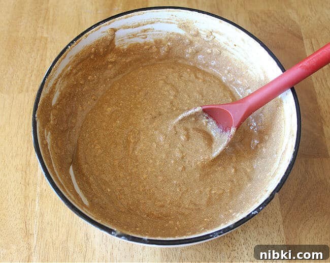 Moist Buckwheat Pumpkin Muffins Recipe 4 Muffin batter in a large bowl with a red spoon.